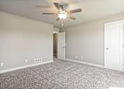 Thumbnail 41 of 47 - A room with a ceiling fan and carpeted floor.