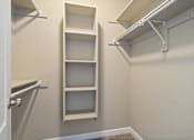 Thumbnail 9 of 47 - A white closet with a shelf and a door.