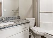 Thumbnail 18 of 23 - A white toilet sits next to a sink in a bathroom.