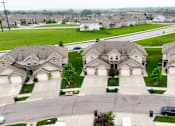 Thumbnail 2 of 23 - A suburban neighborhood with houses and a car parked on the street.