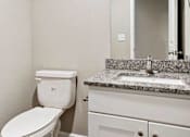 Thumbnail 17 of 23 - A white toilet sits next to a sink in a bathroom.