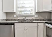 Thumbnail 10 of 23 - A kitchen with white cabinets and a granite countertop.
