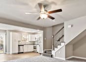 Thumbnail 6 of 23 - A spacious living room with a staircase leading to the upper floor.