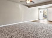 Thumbnail 12 of 23 - A room with a ceiling fan and carpeted floor.