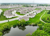Thumbnail 21 of 23 - A bird's eye view of a residential area with houses, a river, and a road.