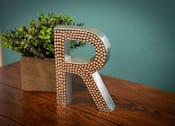 Thumbnail 20 of 28 - A decorative letter R is on a table.