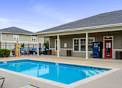 Thumbnail 24 of 28 - A pool in front of a house with a red door.
