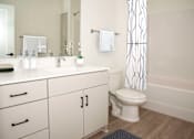 Thumbnail 61 of 79 - A white bathroom with a toilet, sink, and mirror.