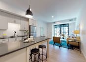 Thumbnail 2 of 79 - A modern kitchen with a bar stool and a dining table.