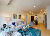 Thumbnail 13 of 79 - A living room with a white couch and a glass coffee table.