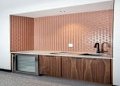 Thumbnail 20 of 79 - A clubroom kitchen with a sink and a wall covered in tiles.
