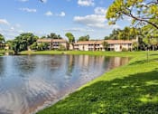 Thumbnail 7 of 7 - A serene lakeside view with a building in the background.