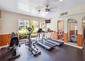 Thumbnail 3 of 7 - A gym with treadmills, elliptical machines, and a stationary bike.