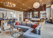 Thumbnail 20 of 29 - A living room with a grey couch and wooden chairs.