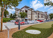 Thumbnail 28 of 29 - A row of cars parked in front of apartment buildings.
