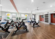 Thumbnail 9 of 32 - A gym with exercise bikes and a mirror on the wall.