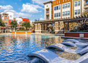Thumbnail 3 of 32 - A pool with a water slide in the middle of it.