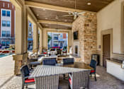 Thumbnail 5 of 32 - A patio with a table and chairs and a grill.