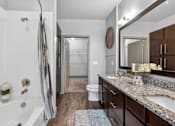 Thumbnail 18 of 32 - A bathroom with a white tub and a wooden floor.