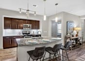 Thumbnail 23 of 32 - A modern kitchen with a refrigerator, sink, and dining area.
