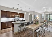 Thumbnail 13 of 32 - A modern kitchen with a dining area and a living room.