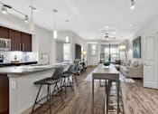 Thumbnail 25 of 32 - A modern kitchen with dark wood floors and white walls.