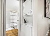 Thumbnail 40 of 41 - A white washing machine is in a small laundry room.