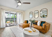 Thumbnail 30 of 41 - A living room with a tan couch, a white coffee table, and a ceiling fan.
