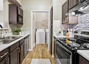 Thumbnail 19 of 41 - A modern kitchen with dark brown cabinets and a white dishwasher.