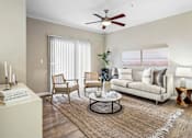 Thumbnail 26 of 41 - A living room with a white couch, a coffee table, and a ceiling fan.