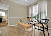 Thumbnail 16 of 41 - A dining room with a bench, chairs, and a table.