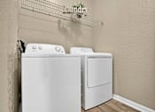 Thumbnail 21 of 41 - Two white front loading washing machines in a laundry room.