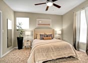 Thumbnail 24 of 41 - A bedroom with a large bed and a ceiling fan.