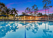 Thumbnail 1 of 22 - A pool with a building and trees in the background.