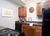 Thumbnail 5 of 28 - A kitchen with black appliances and wooden cabinets.