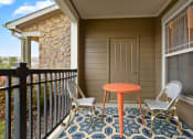 Thumbnail 10 of 48 - Downtown Kansas City, MO Apartments for Rent - Riverstone - Patio with Outdoor Furniture, Black Railing, and Spacious Windows