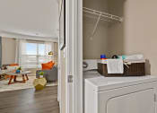 Thumbnail 11 of 48 - Riverstone Apartments In-Unit Laundry Room with Full-Size Washer/Dryer and Shelving