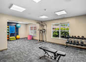 Thumbnail 4 of 35 - A gym room with a bench, weights, and exercise equipment.