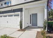 Thumbnail 10 of 25 - the front of a white house with a garage door