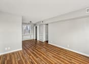 Thumbnail 12 of 15 - A room with wooden floors and white walls.