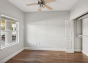 Thumbnail 10 of 27 - A room with a ceiling fan and a door.