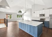 Thumbnail 4 of 13 - A kitchen with a white counter top and blue cabinets.