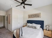 Thumbnail 15 of 26 - A bedroom with a large bed and a ceiling fan.