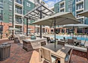 Thumbnail 17 of 66 - A pool area with a table and chairs and umbrellas.