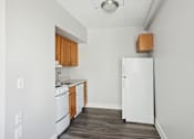 Thumbnail 12 of 13 - A kitchen with white appliances and wooden cabinets.
