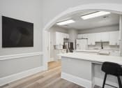 Thumbnail 14 of 25 - an open kitchen and living room with white cabinets and a white counter top