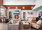 Thumbnail 13 of 32 - A living room with a fireplace and a flat screen TV.