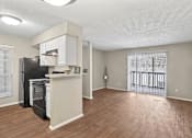 Thumbnail 1 of 14 - A kitchen area with a black fridge and white cabinets.