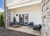 Thumbnail 17 of 26 - An apartment patio with a black sofa and a black chair on the porch.
