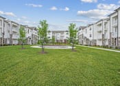 Thumbnail 23 of 36 - A grassy area in front of apartment buildings.